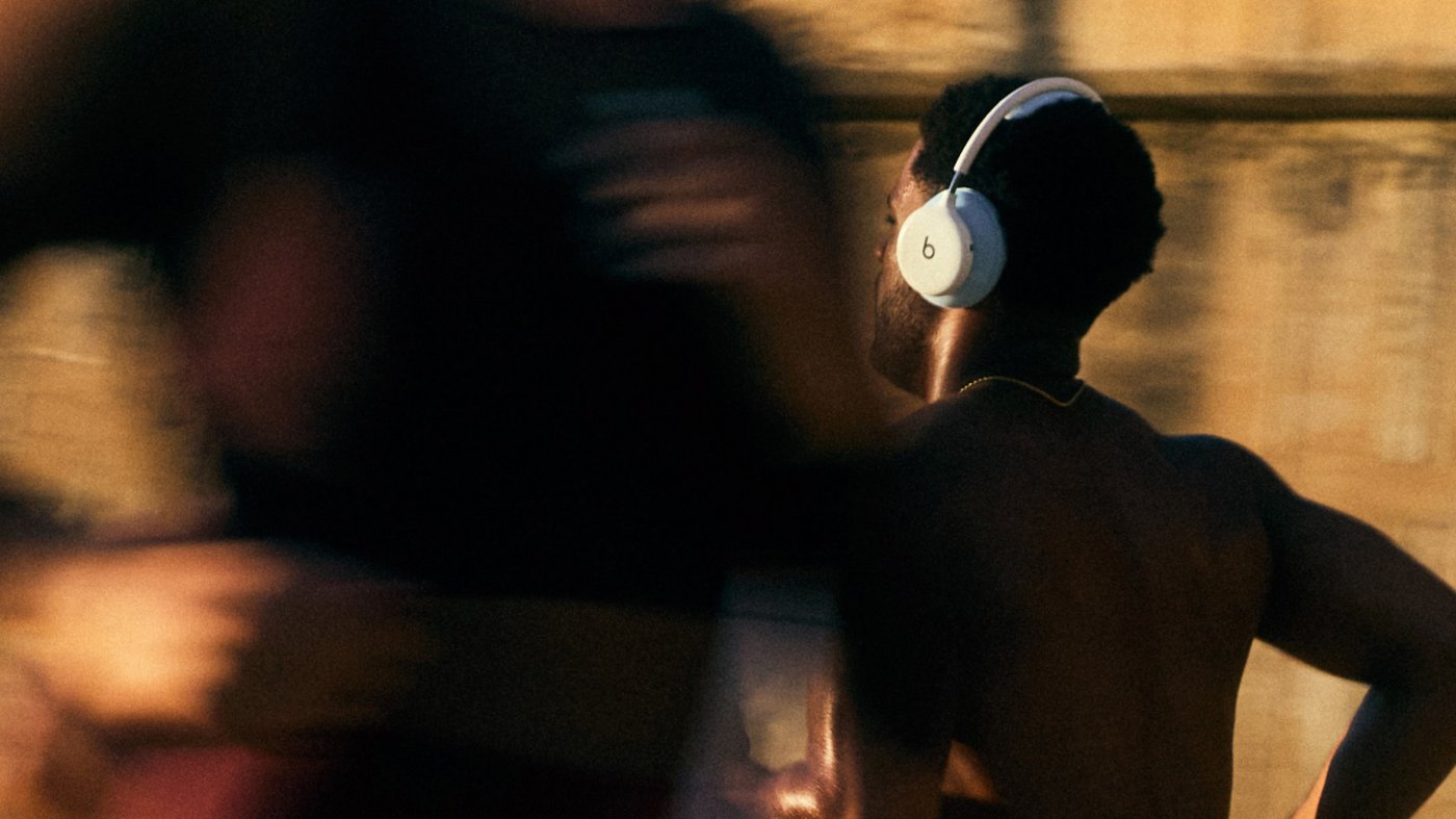 Person wearing white Beats 360 headphones during an outdoor workout