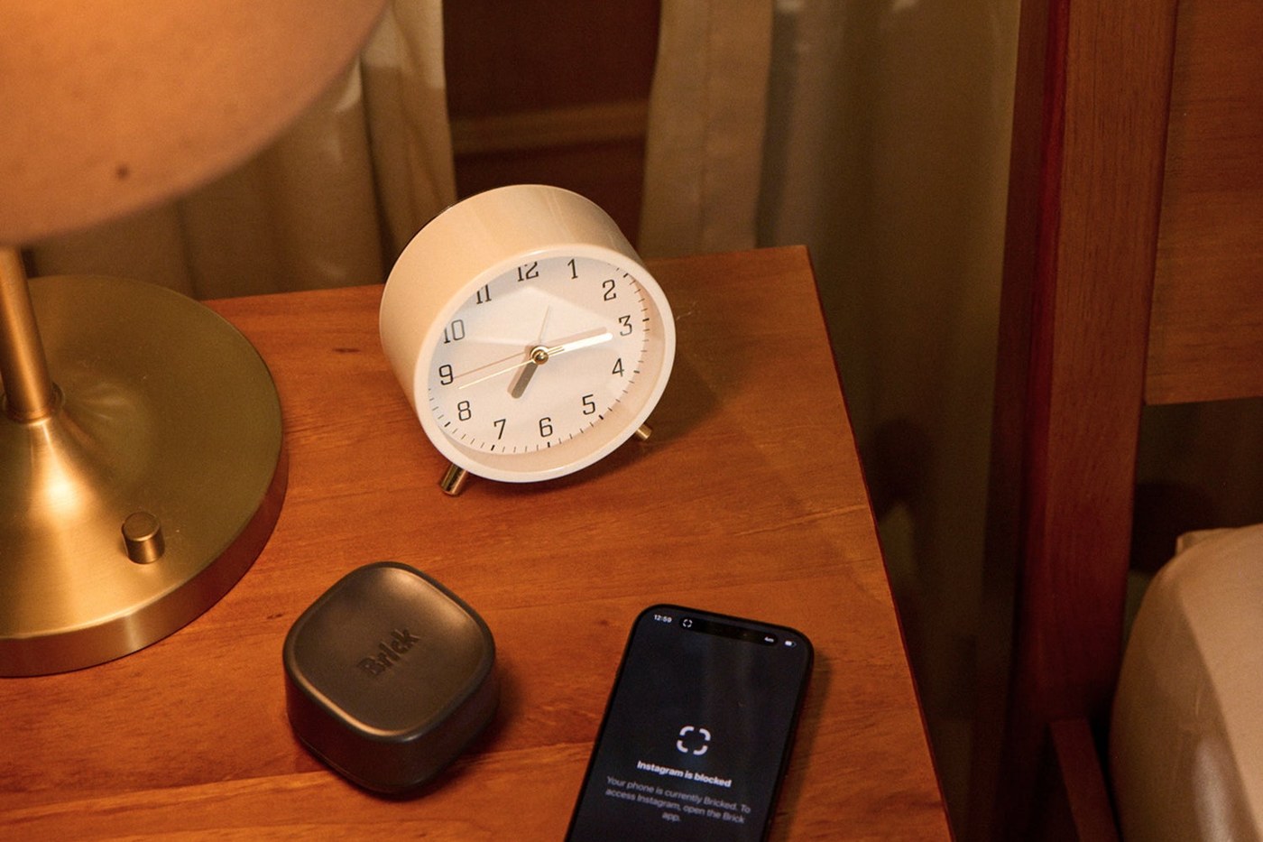 Brick Night on a nightstand, with an iPhone showing a blocked app.