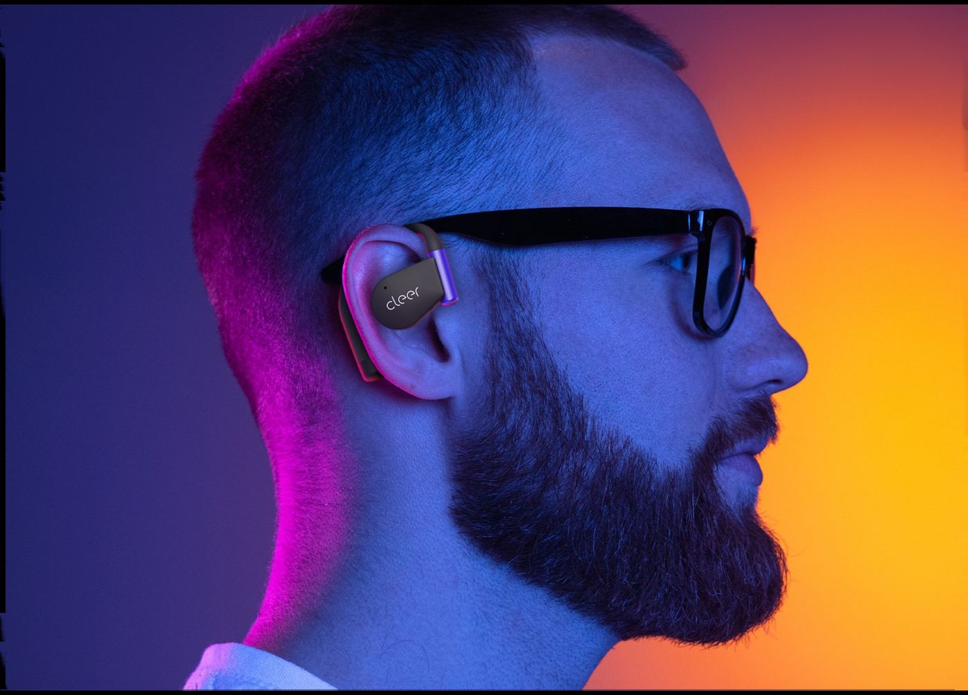 A person in profile wearing a black Cleer ARC 5 Gaming earbud