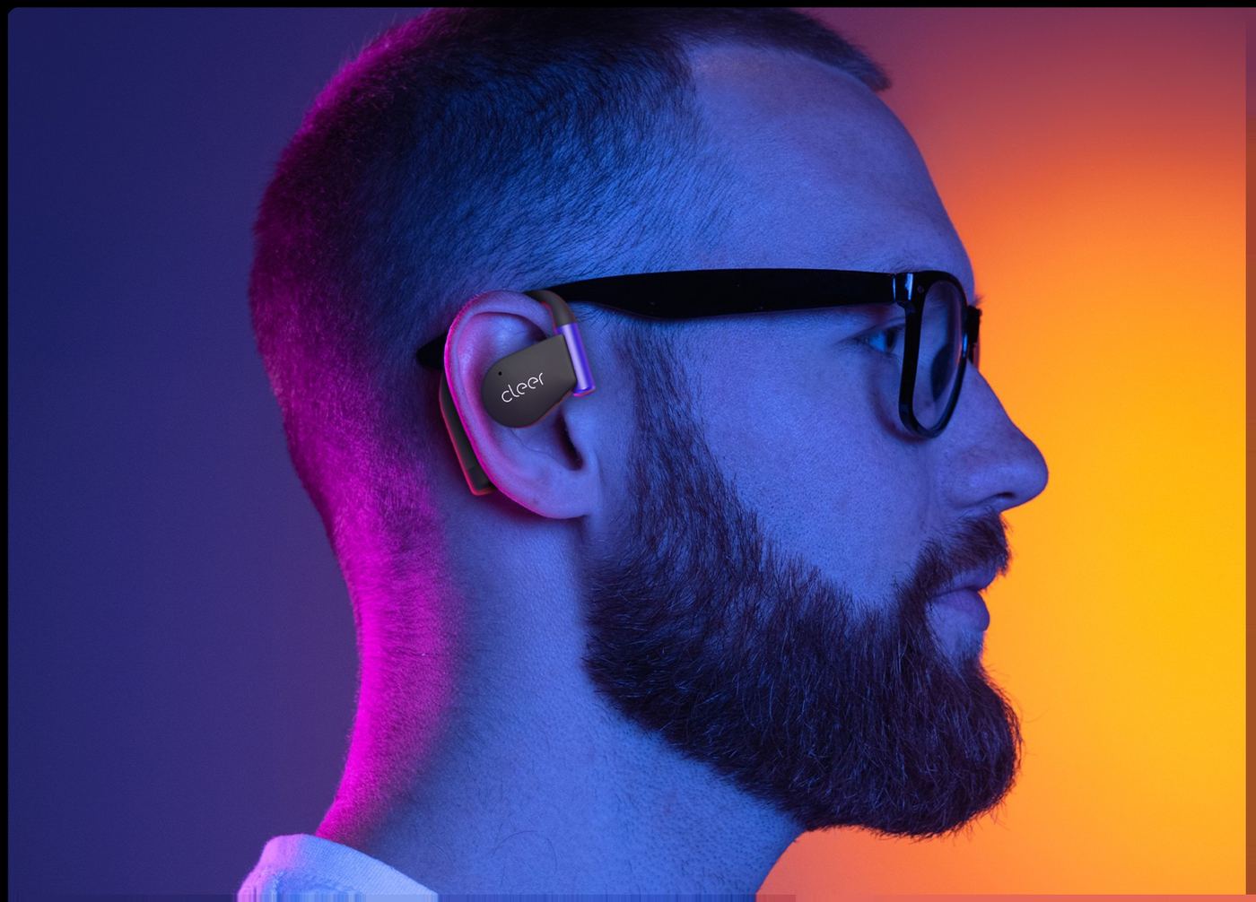 Close-up of a gold Cleer ARC 5 Gaming earbud on the ear