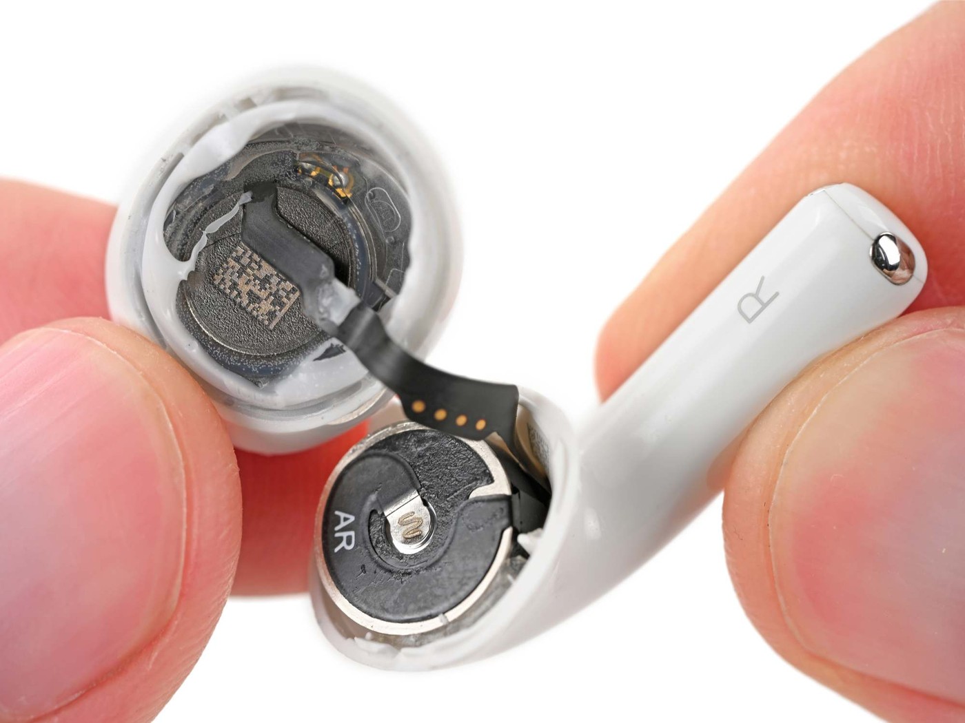 An opened AirPods 5 earbud, with the battery still in place