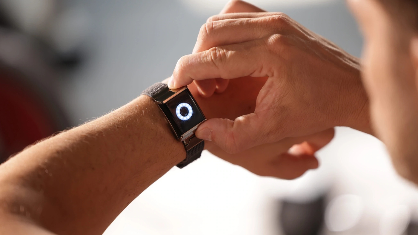 The Alloop Trio worn as a wristband, with the Halo module showing a ring of light on its face