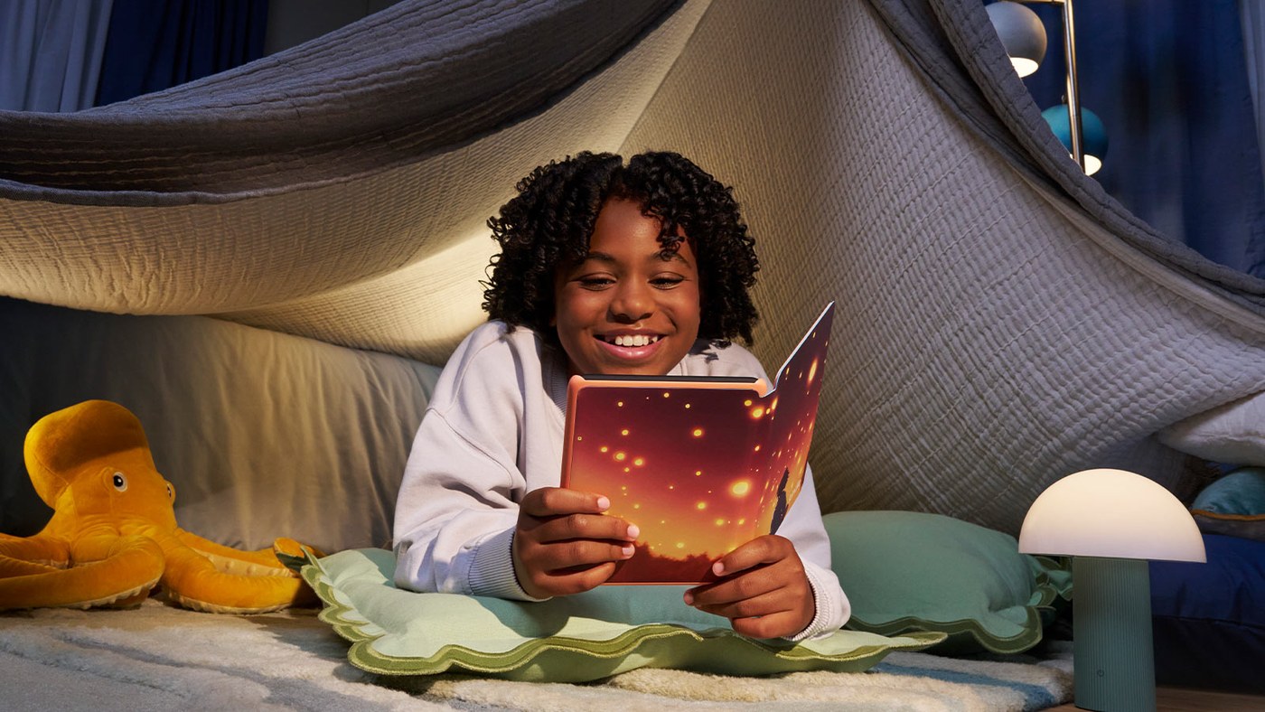 Child reading a Kids Kindle Colorsoft in a blanket fort
