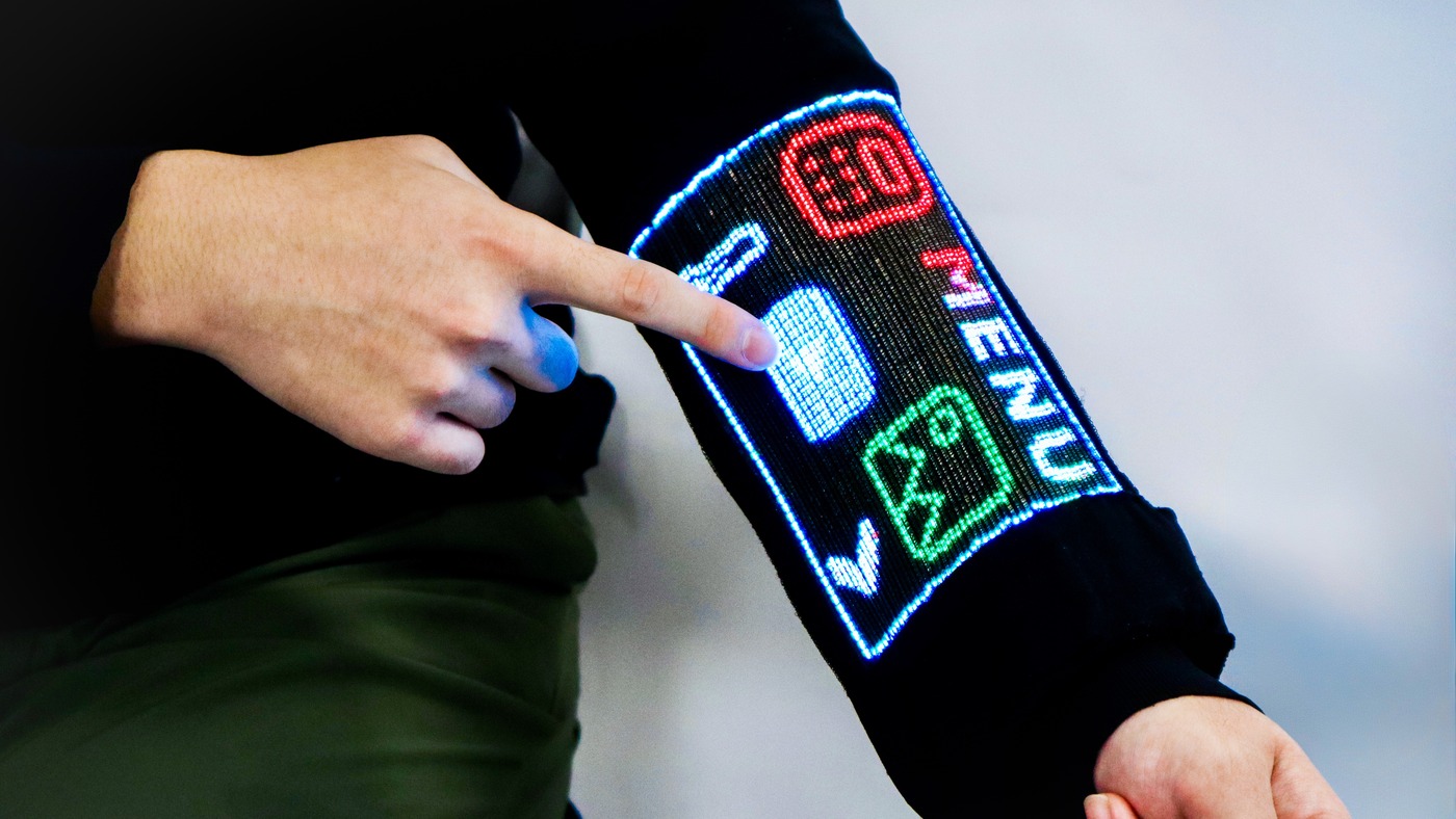 A finger taps the menu on the garment touchscreen built into a sleeve at the National University of Singapore