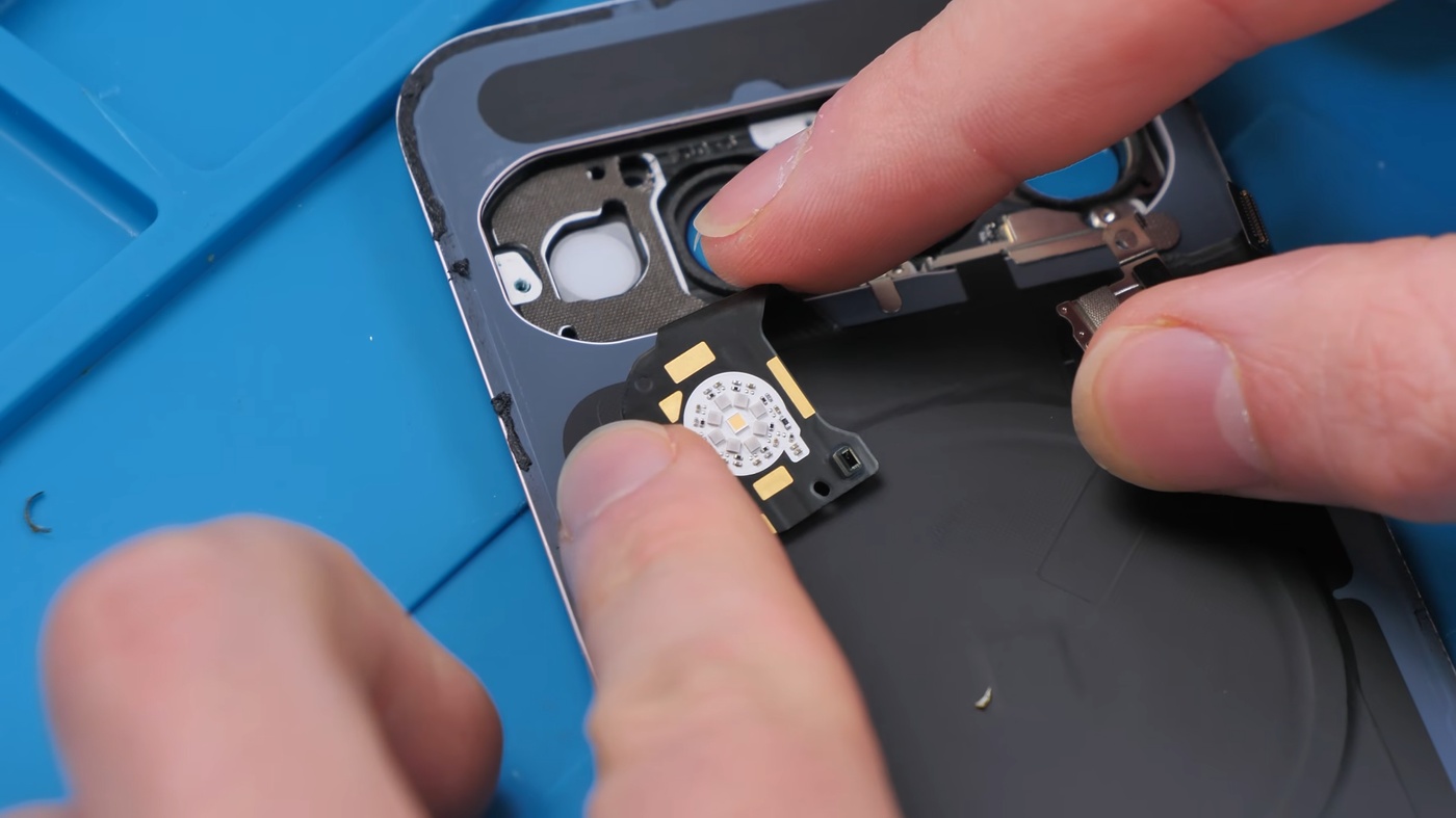Lifting the HiLight board out of a Pixel 11 Pro during the teardown