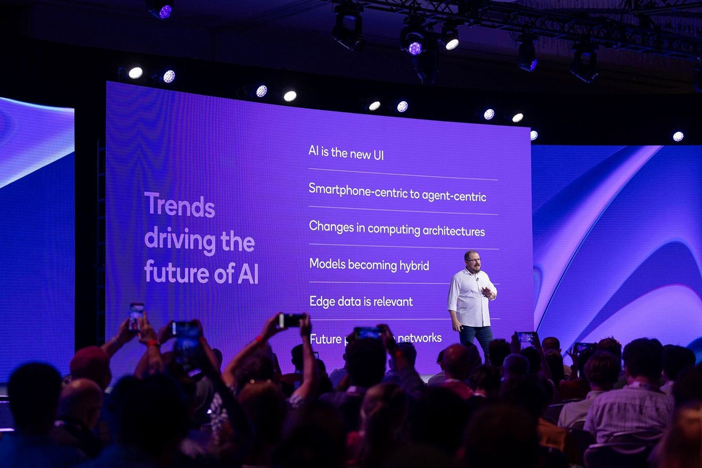 Snapdragon Summit stage with a speaker and a slide on trends driving the future of AI