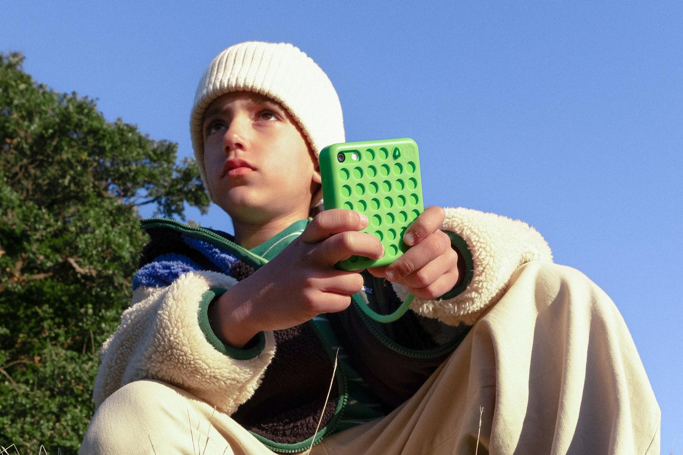 Lifestyle still of child outdoors holding Freckle on grassy hillside