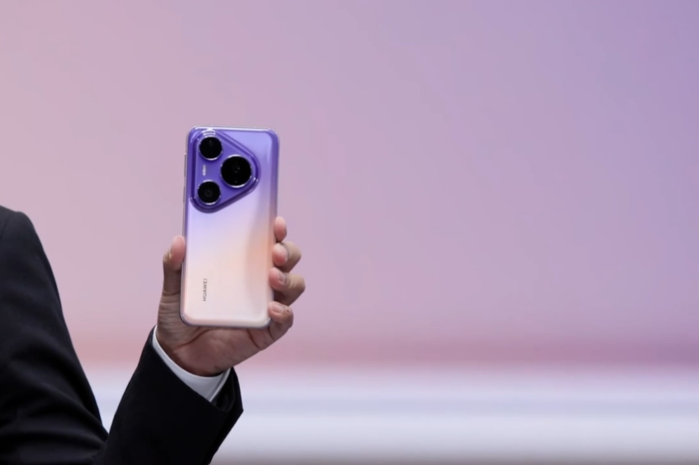A Huawei presenter holds the Pura 90 Plus on stage.