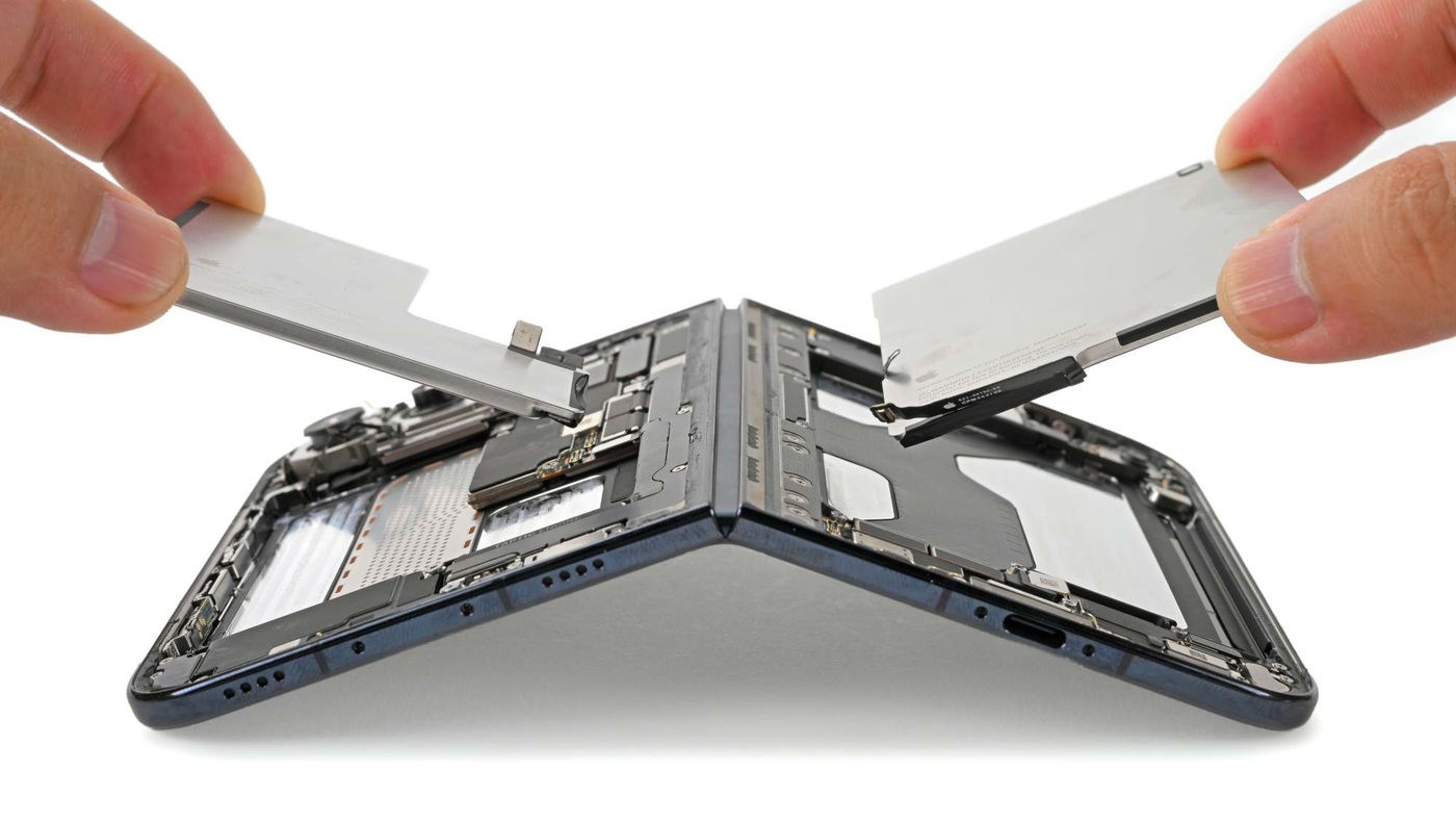 Both batteries lift out after their adhesive is released electrically.