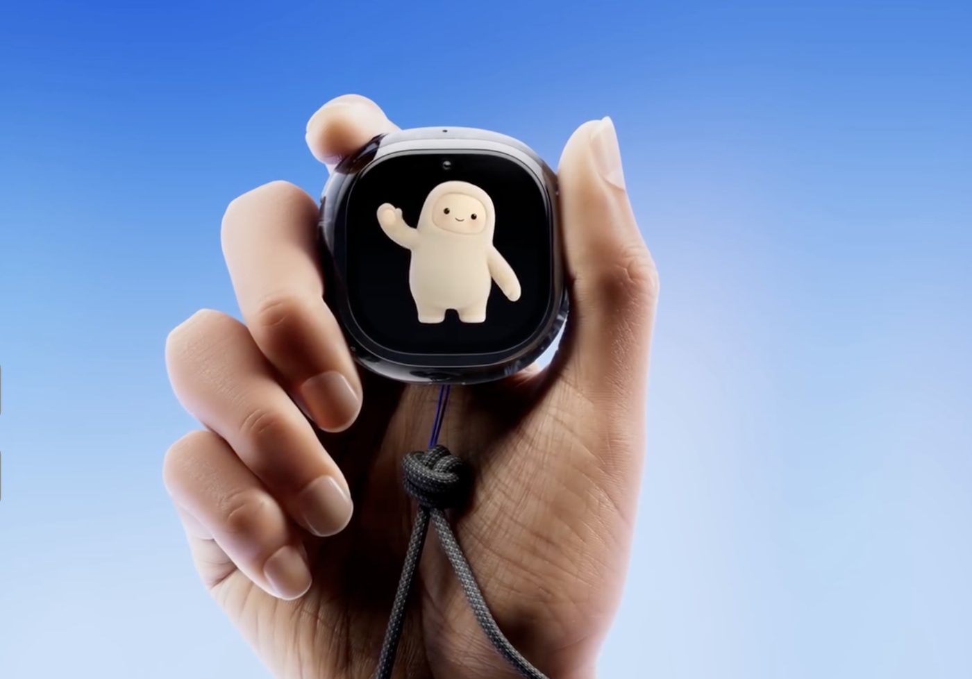 A hand holding Meta Muse Charm, a rounded black puck with a waving white avatar on a small screen