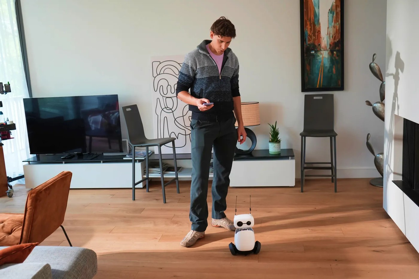 An owner steers Reachy Mini from a phone while watching through the robot’s own camera.