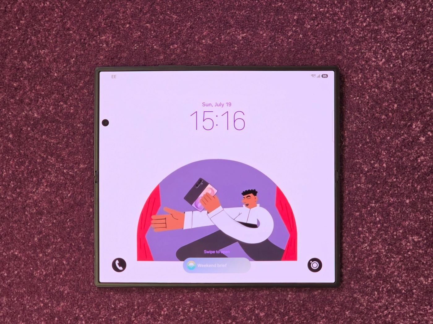 Unfolded Galaxy Z Fold 8 lock screen on a carpet, showing a weekend brief widget