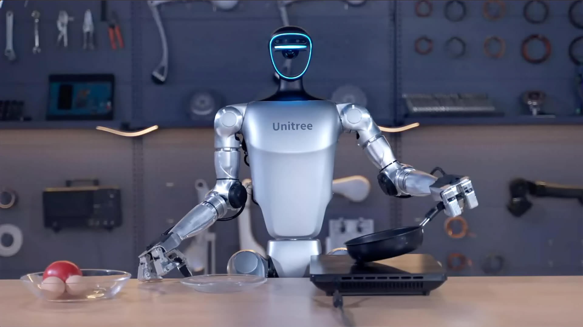Unitree G1+ humanoid holding a pan in a kitchen demo